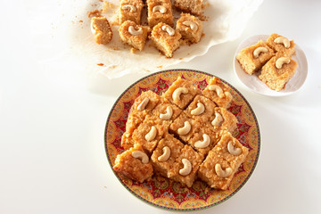 Basbousa or namoora traditional arabic semolina cake with cashew nuts and syrup. Selective focus.