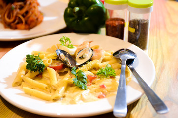 Macaroni cheese and seafood on a white plate. Italian food.