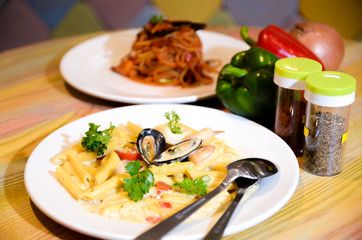 Macaroni cheese and seafood on a white plate. Italian food.