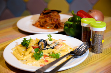 Macaroni cheese and seafood on a white plate. Italian food.