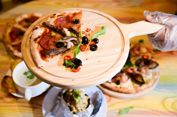 Slice of hot pizza cheese lunch or dinner crust seafood meat topping sauce with bell pepper vegetables delicious tasty fast food italian traditional on wooden board table classic with delivery hand 