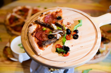 Slice of hot pizza cheese lunch or dinner crust seafood meat topping sauce with bell pepper vegetables delicious tasty fast food italian traditional on wooden board table classic with delivery hand 