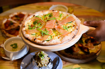Slice of hot pizza cheese lunch or dinner crust seafood meat topping sauce with bell pepper vegetables delicious tasty fast food italian traditional on wooden board table classic with delivery hand 