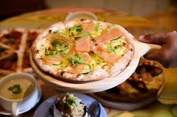 Slice of hot pizza cheese lunch or dinner crust seafood meat topping sauce with bell pepper vegetables delicious tasty fast food italian traditional on wooden board table classic with delivery hand 