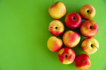 Yellow-red juicy fresh apples lie on a green background. Fresh fruit from the garden.  Diet.