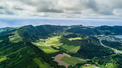 Obraz premium Aerial view on scenic landscape of volcano and green fields around it. Special shape of ground. Top view from drone. Azores islands, Sao Miguel, Portugal.