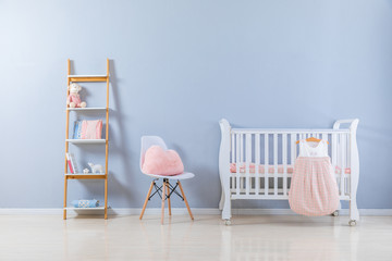 Shot of a crib in a modern white nursery room