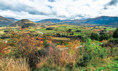 Fototapeta na wymiar Looking at a landscape of farmland and mountains from a viewpoint near Wanaka on New Zealand's south island.