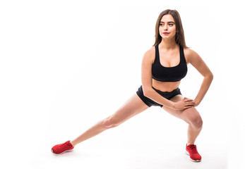 Fototapeta na wymiar Fitness woman doing stretching workout. Full length shot of young woman on white background. Stretching and motivation