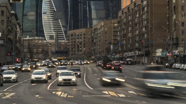Traffic flows of people and cars at the busy city crossroad, time lapse