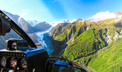 View from the cockpit of a helicopter as it flies over the Fox Glacier on New Zealand's south island. - obrazy, fototapety, plakaty