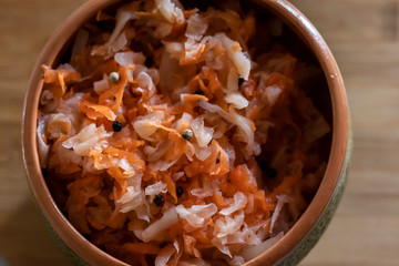 sauerkraut on a cutting board in pottery and light background