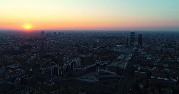 Aerial view of Milan skyline at dawn. Flying over building and boulevard.