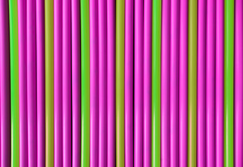 Neon pink and green pattern plastic tubes straws background 
