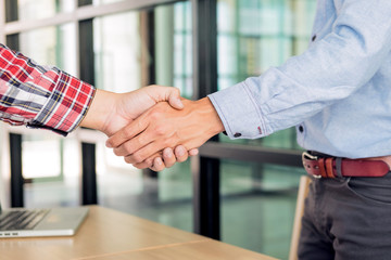 Fototapeta na wymiar Two confident business man shaking hands during a meeting in the office, success, dealing, greeting and partner concept.