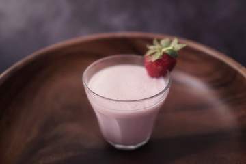 Strawberry milkshake or smoothie with fresh berries on wooden 
