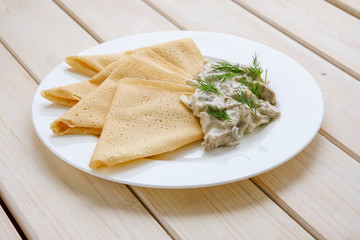 Thin pancakes with mushroom sauce