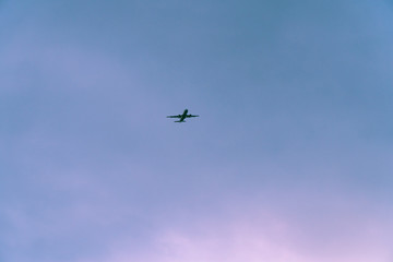 Airplane is flying in the sky of thessaloniki.The sky is almost clear and the time of day is after sunset