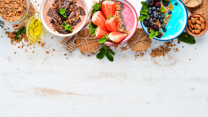 A healthy breakfast. Colorful fruit smoothies with yogurt, fresh fruit and berries. Top view. Free...