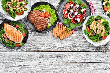 A set of delicious restaurant dishes on a white wooden background Top view. Free space for your text. Flat lay