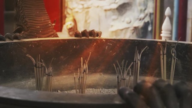 Faith and religious,hope concept.  Smoke from joss sticks in burner moving in front of altar table at chinese shrine with sunray ,hd slow motion.
