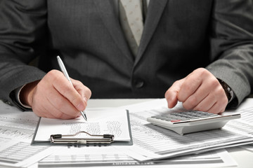 Businessman working in an office. Hands and documents closeup.