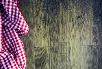Red checkered kitchen towel on wooden background. Culinary background. Table setting. Preparing the food. Top view, copy space.
