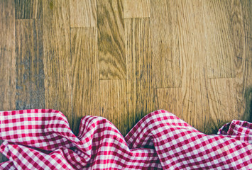 Red checkered kitchen towel on wooden background. Culinary background. Table setting. Preparing the food. Top view, copy space.