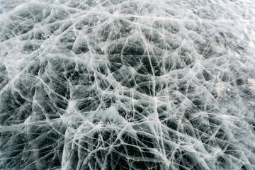 Texture of frozen ice with cracks, frozen like a cobweb. Baikal, Russia