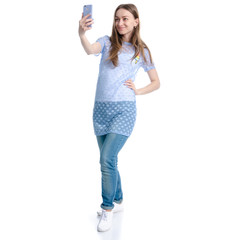 Woman in blue jeans making selfie on smartphone on white background isolation