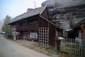 Fototapeta na wymiar large rock above cottages in village Karba