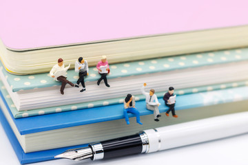Miniature people: Business team reading book, education or business concept.