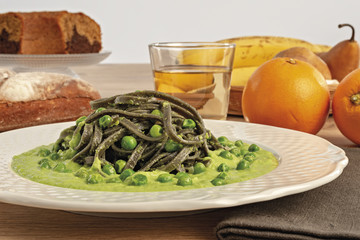 pasta al nero di seppia con salsa di piselli da fronte piatto tondo altra vista