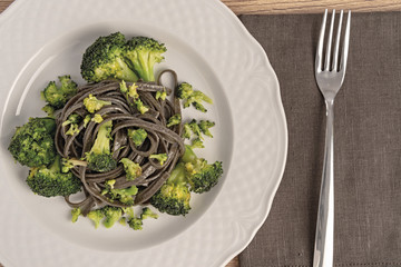 pasta al nero di seppia con broccoli dall'alto piatto tondo vicino