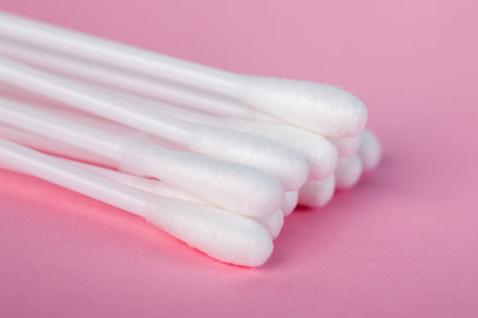 sticks for cleaning ears on a pink background