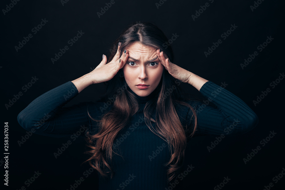 Wall mural Disappointment stressed woman touching head isolated on black background - Wall murals