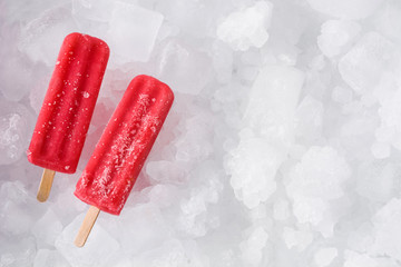 Strawberry popsicles on ice cubes. Top view. Copyspace