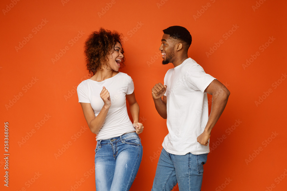 Wall mural Cute african-american couple in love flirting and dancing together