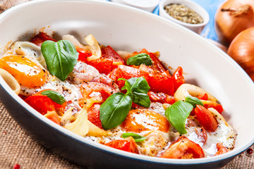 Shakshuka - fried eggs with vegetables in frying pan