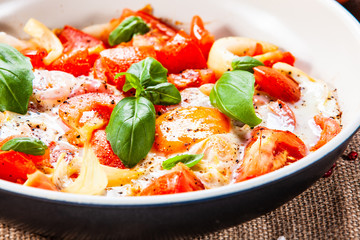 Shakshuka - fried eggs with vegetables in frying pan