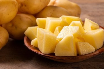 Potatoes and potato sliced on wooden table. Selective focus