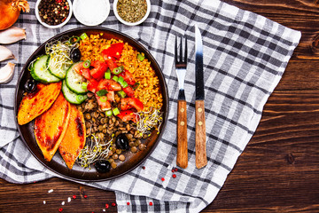 Groats with lentils and vegetables on wooden table