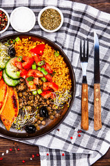 Groats with lentils and vegetables on wooden table