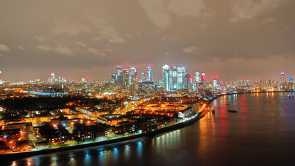 Naklejka na ściany i meble Aerial drone night shot from iconic Canary Wharf skyscrapers business area, Isle of Dogs, London, United Kingdom, 