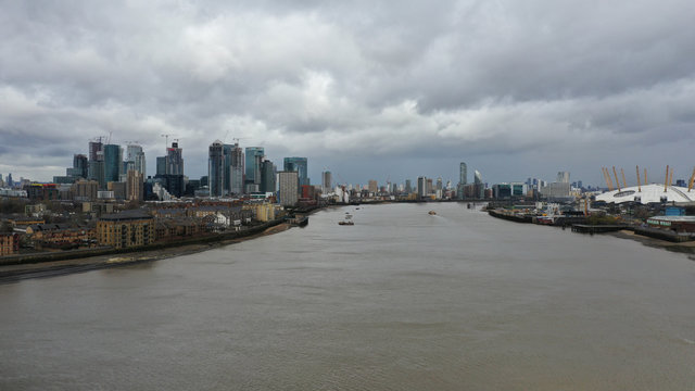 Aerial bird's eye view photo taken by drone of Canary Wharf skyline as seen from river Thames with beautiful cloudy sky, Isle of Dogs, London, United Kingdom