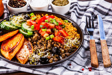Groats with lentils and vegetables on wooden table
