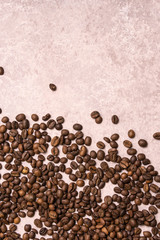 Roasted coffee beans in bulk on a light pink background. dark cofee roasted grain flavor aroma cafe, natural coffe shop background, top view from above, copy space
