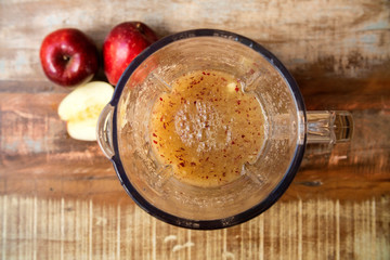 Making juice with apple fruit, blender top view