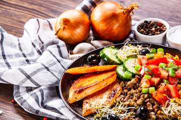Groats with lentils and vegetables on wooden table