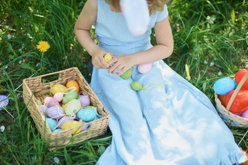 Cute funny girl with Easter eggs and bunny ears at garden. easter concept. Laughing child at Easter egg hunt © Serenkonata